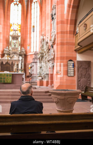Man sitting in church with room for contemplation and religious thoughts , Wertheim in Germany Stock Photo