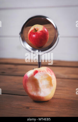 expectations and reality concept - bitten apple with perfect mirror reflection Stock Photo