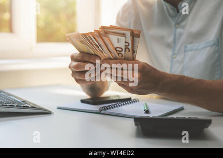 business success - businessman counting cash money in the office Stock Photo