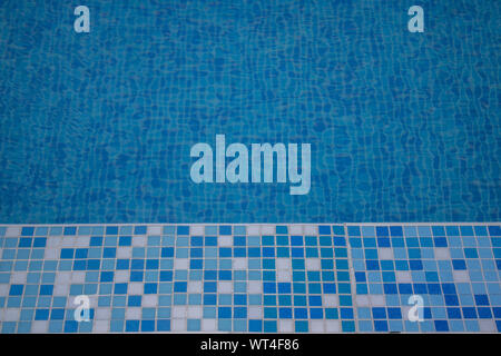 Close up of a blue hotel Swimming pool with blue mosaic tiles of the pool. Stock Photo