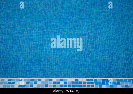 Close up of a blue hotel Swimming pool with blue mosaic tiles of the pool. Stock Photo