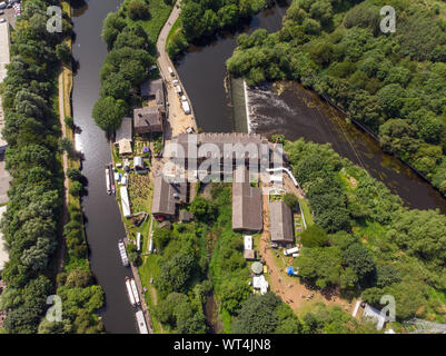 Aerial footage of The Made in Leeds Festival located at the Thwaite Mills along the side of the Leeds Canal showing the water and waterfall on a sunny Stock Photo