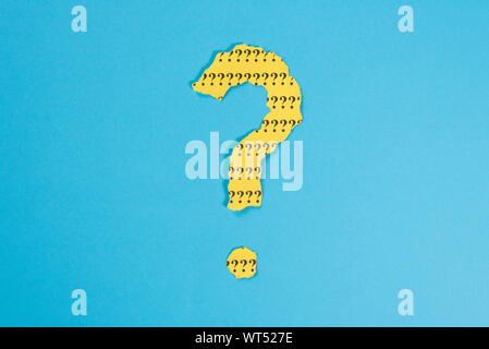 question mark symbol from a teared yellow paper on a blue background. Concept of FAQ, Q and A, Questions and riddle Stock Photo