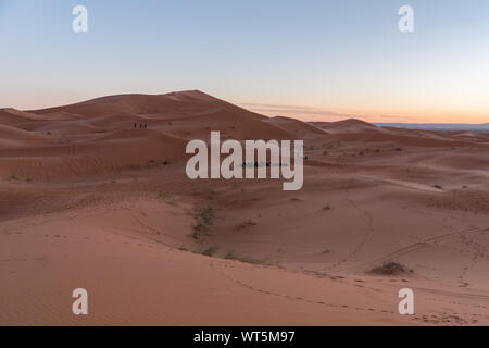 Gorgeous and scenic desert scene with the moon crescent high above beautiful sand dunes Erg Chebbi, Morocco, Merzouga Stock Photo