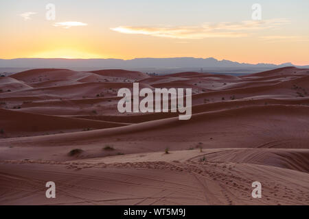 Gorgeous and scenic desert scene with the moon crescent high above beautiful sand dunes Erg Chebbi, Morocco, Merzouga Stock Photo