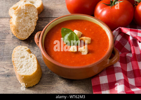 Tomato soup in brown bowl on wooden table Stock Photo
