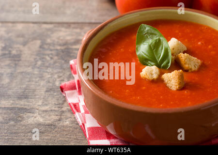 Tomato soup in brown bowl on wooden table Stock Photo