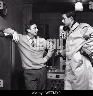 1958, historical, the singer, entertainer and actor Tommy Steele in a recording studio talking to a journalist, London, England, UK. Regarded as Britain's first teen idol and rock and roll star, Bermondsey born Steele achieved number one in the UK charts with 'Singing the Blues' in 1957. He was discovered at the famous soho venue, the '2 is' coffee bar. Stock Photo