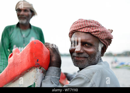 COCHIN, INDIA - 30 NOVEMBER 2018: Portrait of the fisherman from the Fort Cochin leaning against a fishing boat Stock Photo