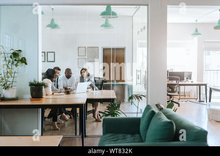 Diverse work colleagues meeting together in an office