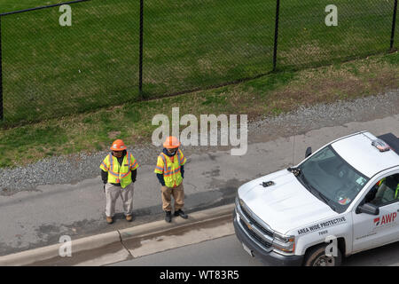 Charlotte, USA - February 24, 2019: View of two workers from Area White Protective in Charlotte, USA. Stock Photo