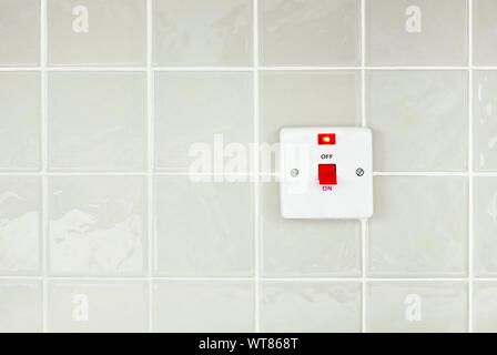 Kitchen appliance on off switch on a glossy tiled wall Stock Photo