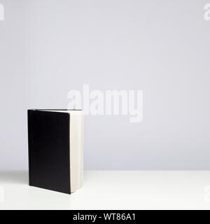 Hardback book with blank cover standing upright on a table Stock Photo