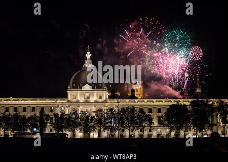 LYON, FRANCE - JULY 14, 2019: Fireworks bursting over Hotel Dieu in Lyon for French National Holiday, Bastille day, while Basilique de Fourviere Basil Stock Photo