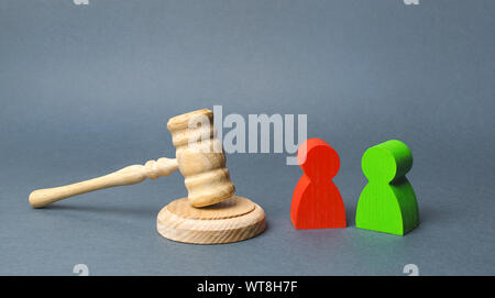 Two figures of people opponents stand near the judge's gavel. The judicial system. Conflict resolution in court, claimant and respondent. Court case, Stock Photo