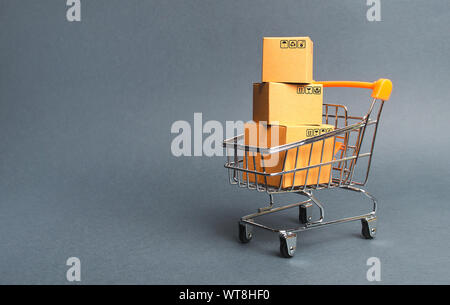 A pile of cardboard boxes in a supermarket trolley. concept of shopping in the online store . E-commerce, sales and sale of goods through online tradi Stock Photo
