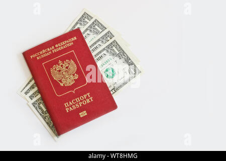 The Russian foreign passport lies on top of one-dollar bills on a light background. Traveling abroad, budget vacation. Stock Photo