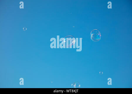 Soap bubbles drifting against the blue summer sky of London. Stock Photo