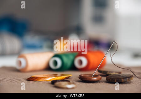 Colorful thread spools used in textile industry and buttons with a needle Stock Photo