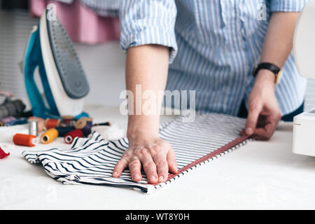 Young woman working with measuring tape in tailor shop Stock Photo