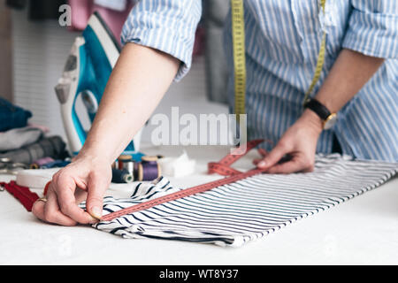 Young woman working with measuring tape in tailor shop Stock Photo