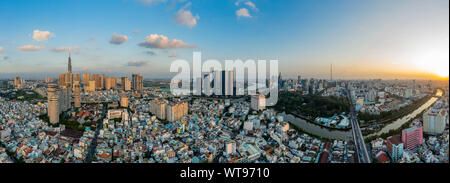 Ultra hi resolution dramatic Aerial panorama from Binh Thanh district Ho Chi Minh City taking in major city buildings and river front at sunset Stock Photo
