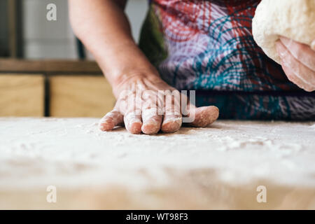 Skilled baker woman kneading dough. Professional bakery concept. Stock Photo