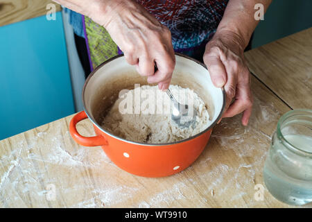 Hands of senior woman mixing dough close-up Stock Photo