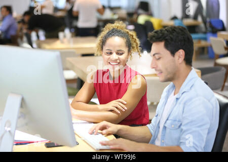 Colleagues Discussing Over Computer In Office Stock Photo