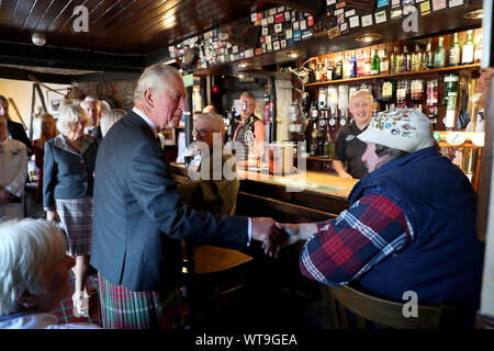 The Prince of Wales and Duchess of Cornwall, known as the Duke and Duchess of Rothesay when in Scotland, the Duke has a pint at the Harbour Inn during a visit to the coastal village of Garlieston, Wigtownshire, where the port played an important role in D-Day preparations in 1944, in the testing of the Mulberry Harbours. Stock Photo