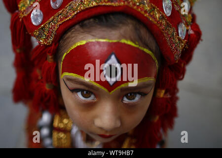 Kathmandu, Nepal. 11th Sep, 2019. A girl adorned as a Living Goddess looks on during Kumari Puja festival in Kathmandu, Nepal. Hundreds of young girls under the age of nine gathered around the temple to offer worship for good luck, protection from evil and prevent from diseases. Credit: Skanda Gautam/ZUMA Wire/Alamy Live News Stock Photo