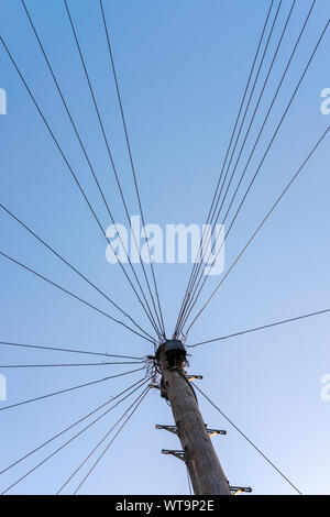 Network communication cables on electric pole agains blue sky, Epsom Surrey Stock Photo