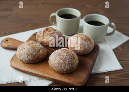 french rye bread with cups of coffee isolated on wooden table Stock Photo