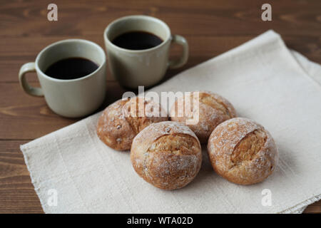 french rye bread with cups of coffee isolated on wooden table Stock Photo