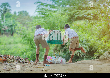 Male Students help to remove rubbish from the classroom to pile waste Stock Photo