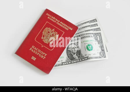 The Russian foreign passport  lies on top of one-dollar bills on a light background. Traveling abroad, budget vacation. Stock Photo