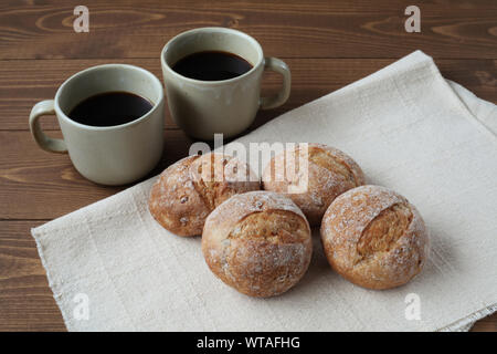 french rye bread with cups of coffee isolated on wooden table Stock Photo