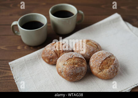 french rye bread with cups of coffee isolated on wooden table Stock Photo