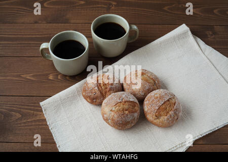 french rye bread with cups of coffee isolated on wooden table Stock Photo