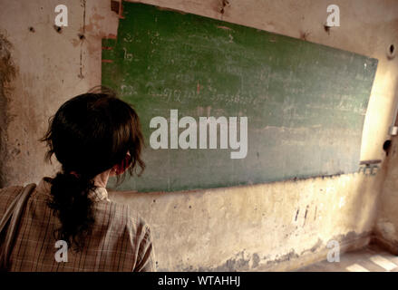 Woman observes blackboard inside Tuol Sleng Genocide Museum Stock Photo