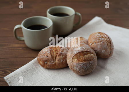 french rye bread with cups of coffee isolated on wooden table Stock Photo