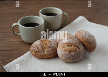 french rye bread with cups of coffee isolated on wooden table Stock Photo