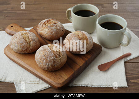 french rye bread with cups of coffee isolated on wooden table Stock Photo