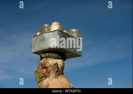 Milkman carrying milk pots in the head Stock Photo