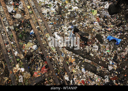 Boy walks in the rubbish along the railway of Kurla Stock Photo