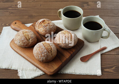 french rye bread with cups of coffee isolated on wooden table Stock Photo