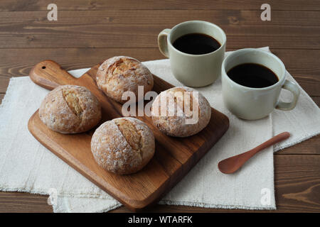 french rye bread with cups of coffee isolated on wooden table Stock Photo