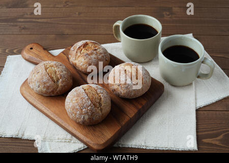 french rye bread with cups of coffee isolated on wooden table Stock Photo