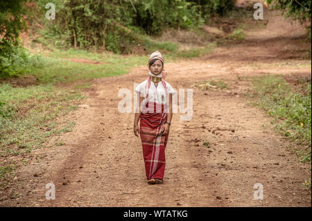 Long Neck woman walking in the tribe dirt road