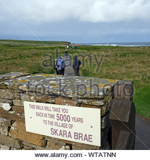 Tourists visiting Skara Brae, a stone-built Neolithic settlement, located on Mainland Orkney, Scotland Stock Photo